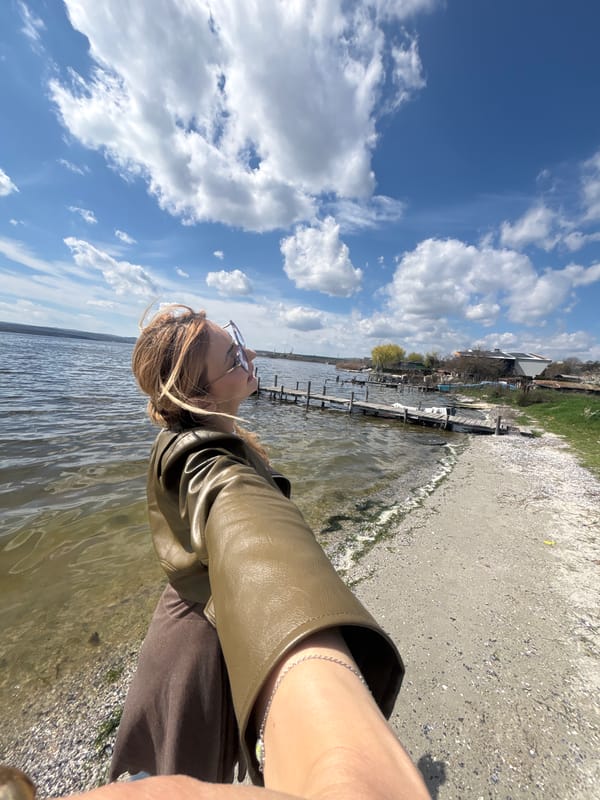 Woman photographs coastal scene with abandoned boat in Bulgaria