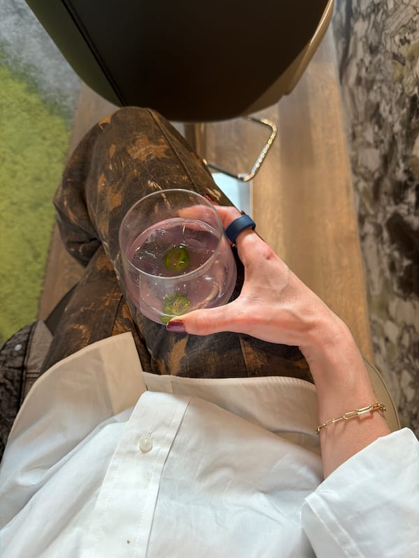 Person enjoys clear cocktail with green garnish in Dallas