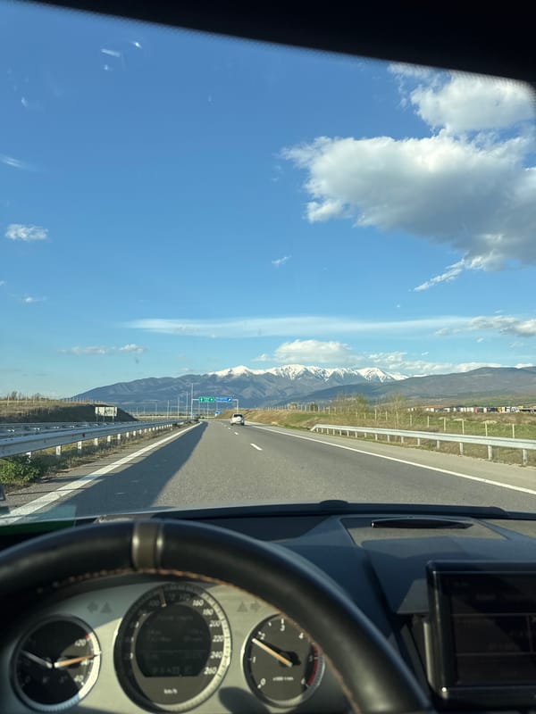 Driver navigates highway near Belo Pole amid mountain scenery