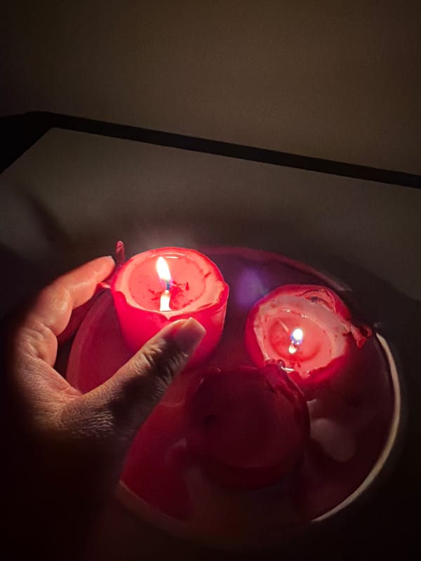 Person holds lit red candle in Leningradskaya, Russia