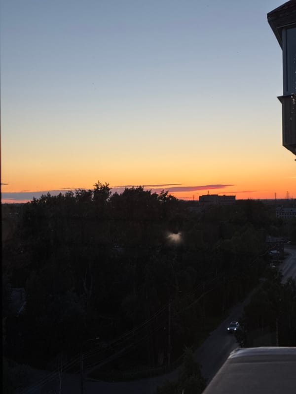 Sunset observed across city skyline during evening hours