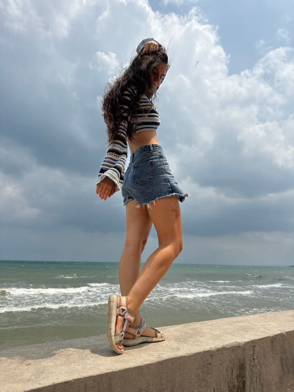 Woman poses on ocean ledge in Vietnam dawn