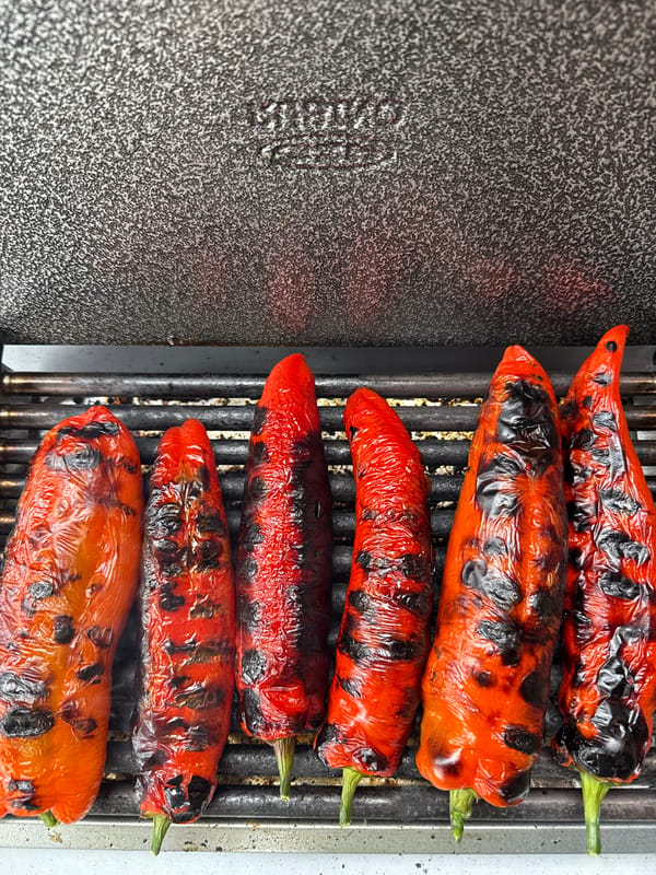 Red bell peppers grilled on metal grate in London