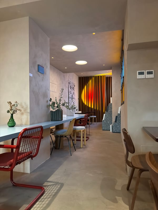 Inside a sleek, minimalist Milan café with pale blue counter