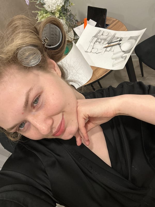 Woman in hair curlers poses with art supplies in Kazan