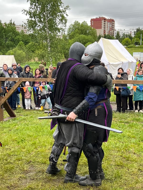 Medieval reenactment gathering features armored combat in field