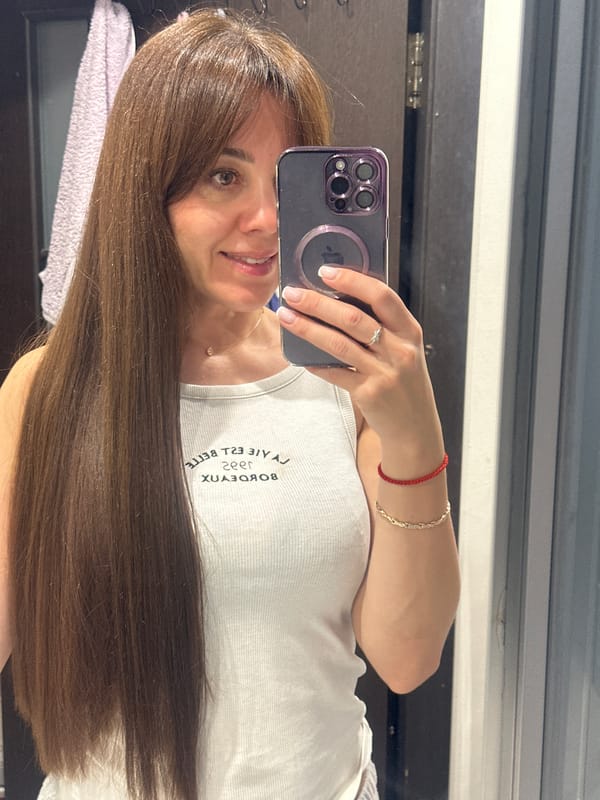 Woman Takes Mirror Selfie with Purple iPhone in Riga