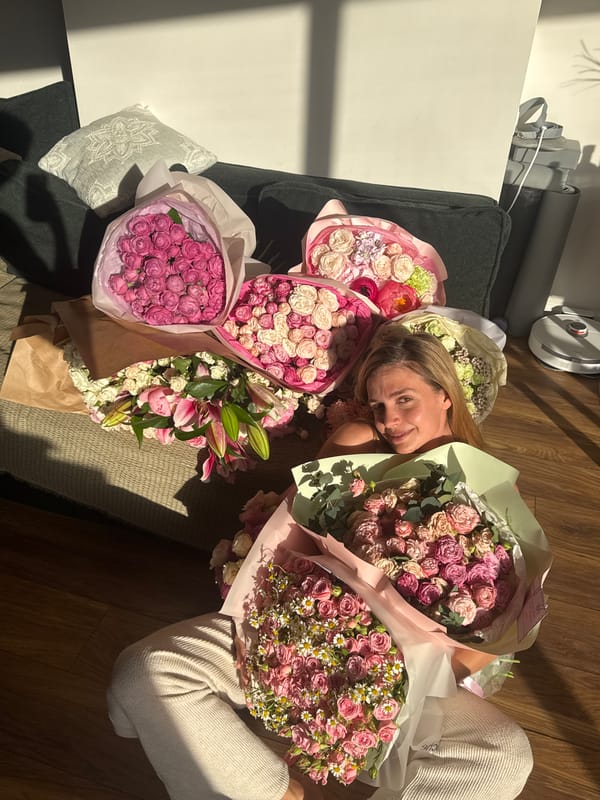 Woman surrounded by flower bouquets in indoor photoshoot session