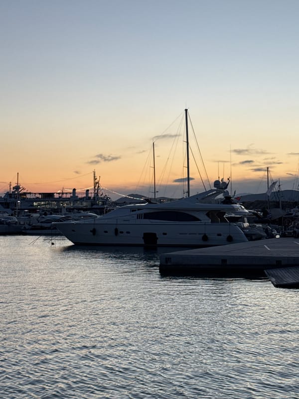 Dusk settles over a Greek marina and its hillside city