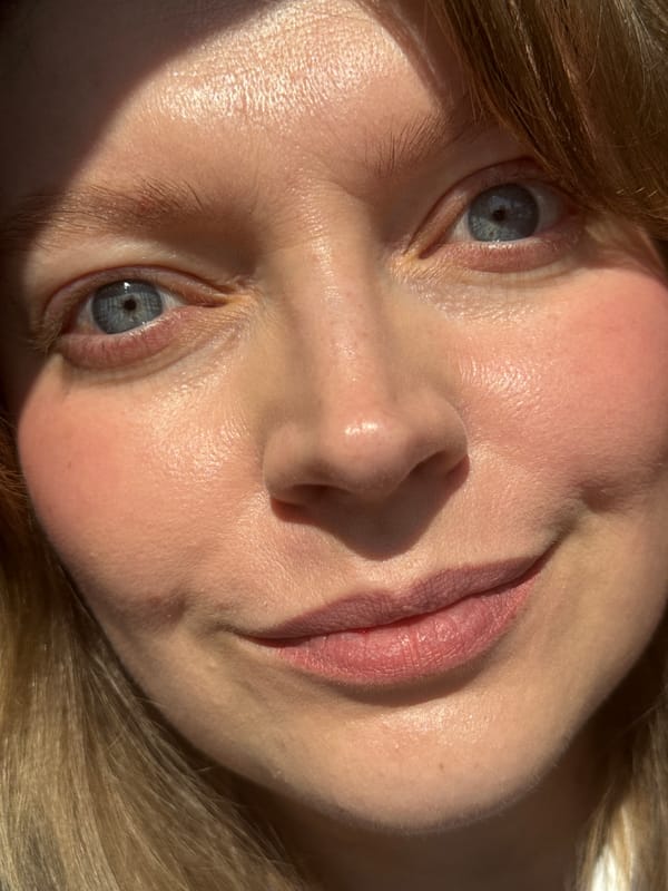 Blonde woman photographed indoors wearing striped shirt