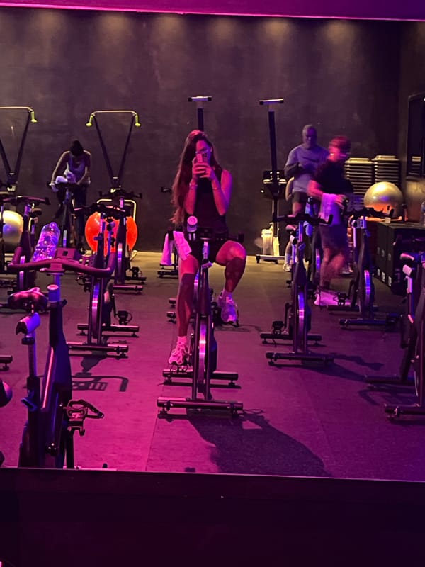 Early morning cycling class captured in purple-lit fitness studio