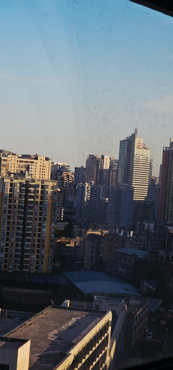 Jiulongpo's dense skyline and a stepped glass skyscraper up close