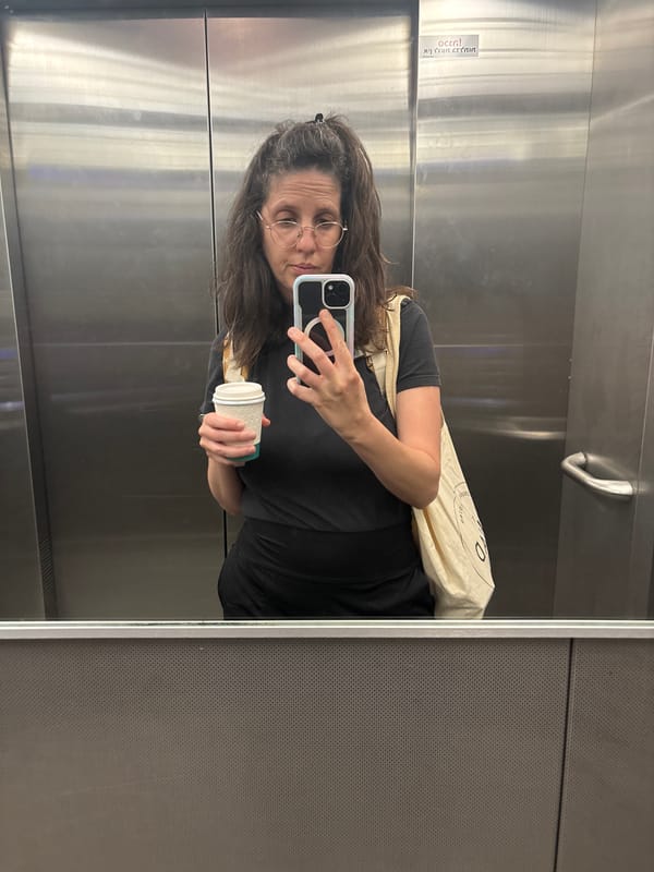 Woman takes elevator selfie with coffee cup in Tel Aviv