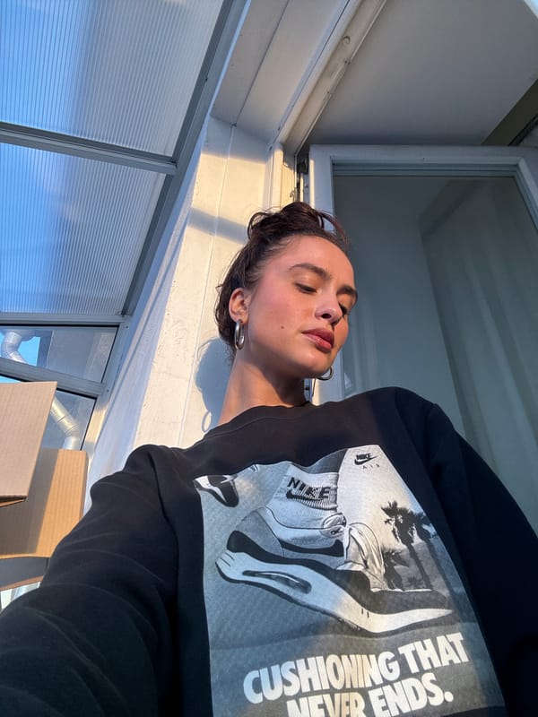Woman in Nike sweatshirt photographed in plant-filled indoor space