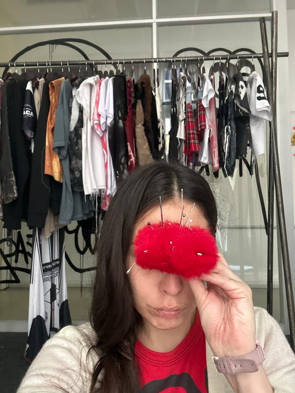 Woman hand-sews pink corduroy garment in Buenos Aires workspace