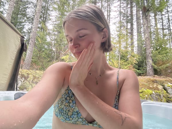 Woman relaxes in outdoor forest hot tub in Whistler