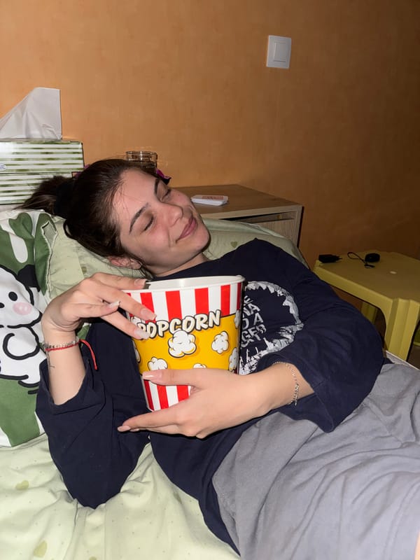 Woman enjoys popcorn while relaxing on bed in Sliven