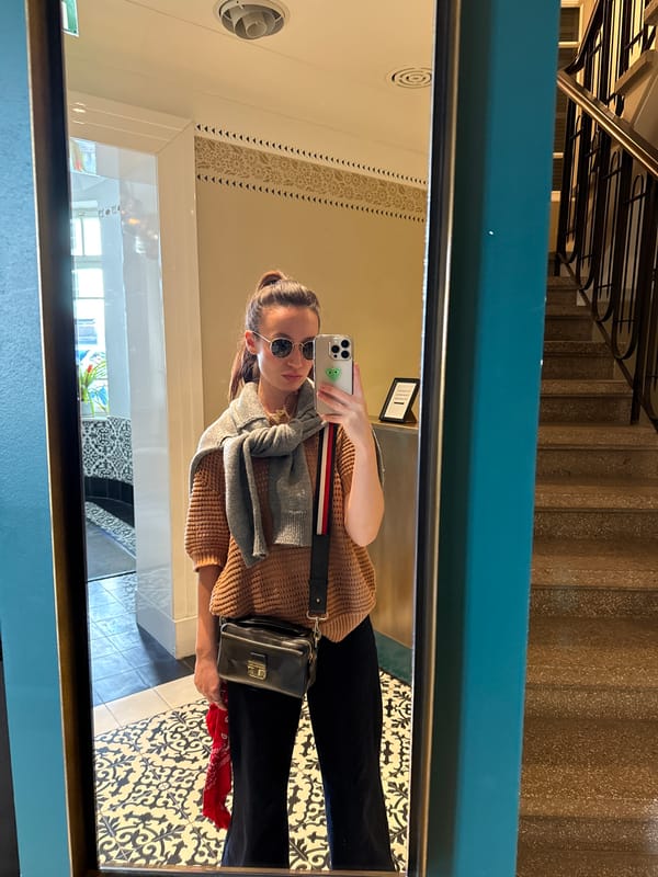 Woman takes mirror selfie in Tel Aviv hallway