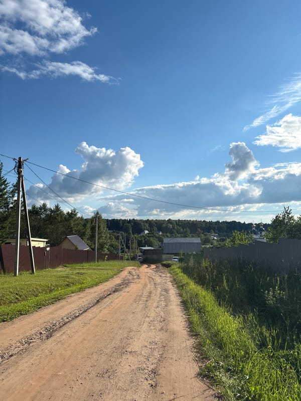 Orange tanker trucks parked in a rural Russian field on a summer day