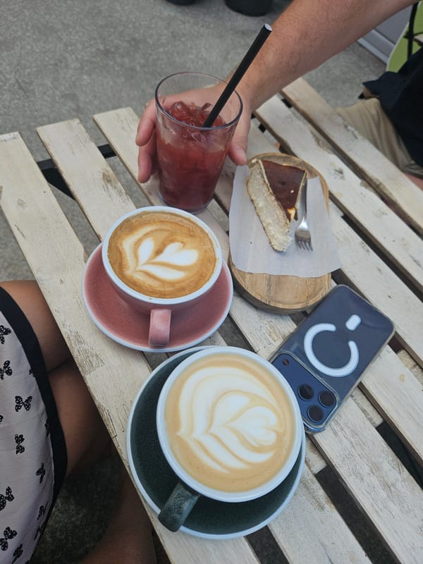Café table with lattes, cheesecake, and iced drink, multiple angles