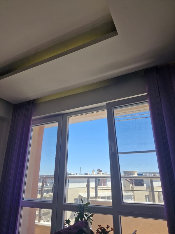 City view captured through violet-curtained window on clear day