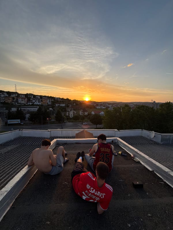 Young men watch sunset from Bragança rooftop