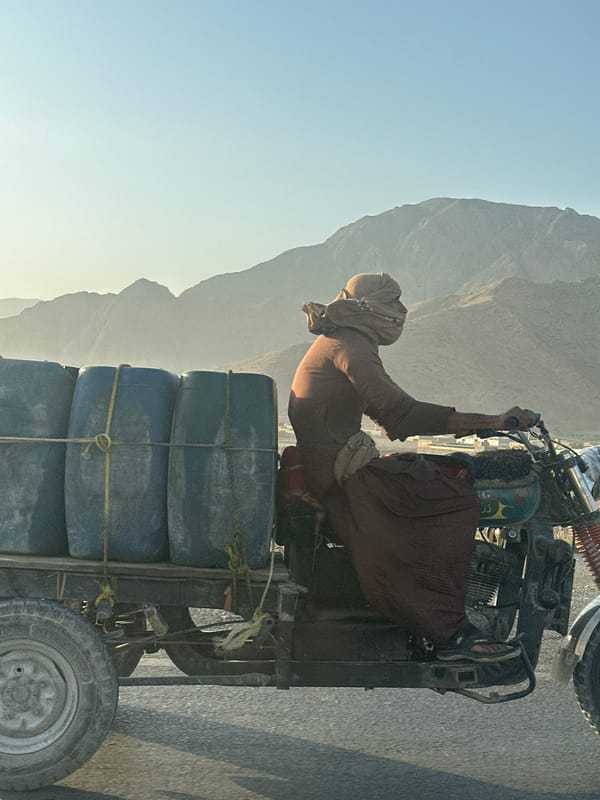 Blue barrels loaded on a three-wheeler in Quetta