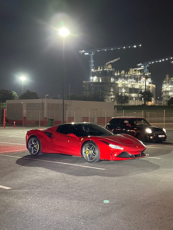 Nighttime car event at Dubai Autodrome with racing and sports cars