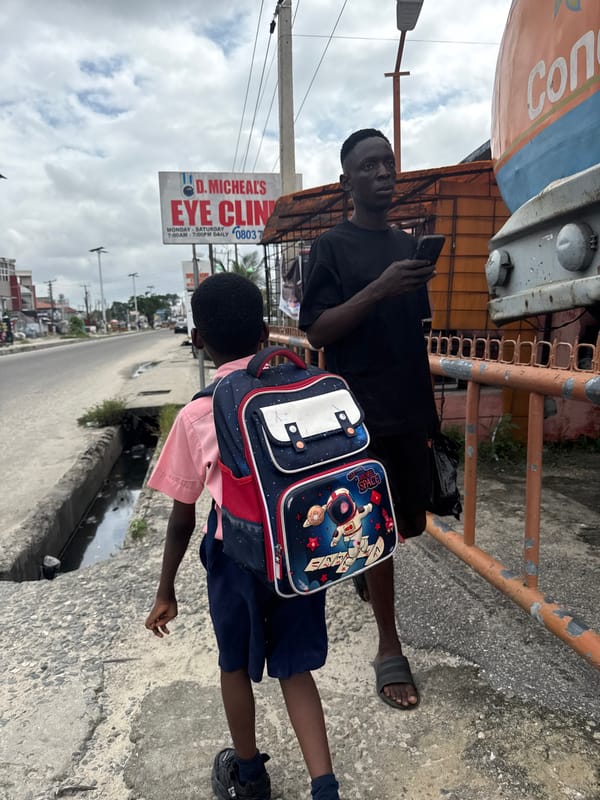 Afternoon street life in Ado, Nigeria — students and passersby