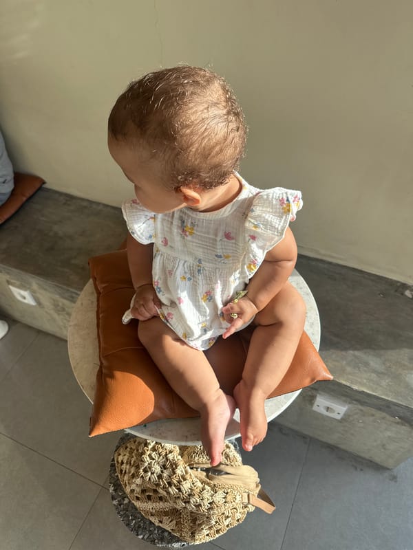 Baby in floral dress photographed with flowers in North Kuta