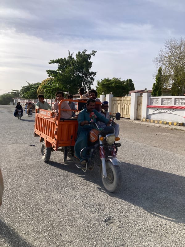 Orange rickshaw spotted on Uthal street under cloudy skies