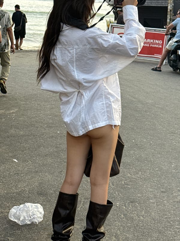 Woman in white outfit observed near shoreline in North Kuta