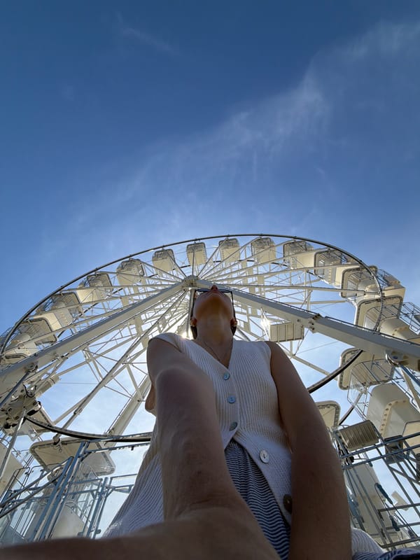 Woman takes coffee selfies at Budva Ferris wheel attraction