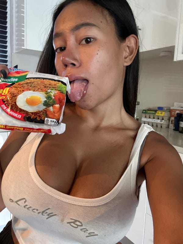 Woman poses playfully with instant noodles in Maroubra kitchen