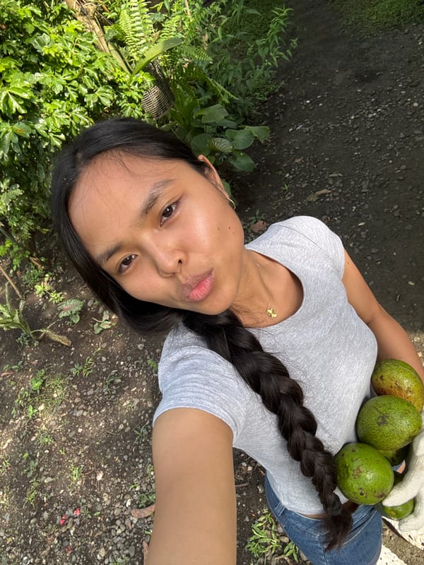 Woman holds avocados outdoors in Carmen, Philippines
