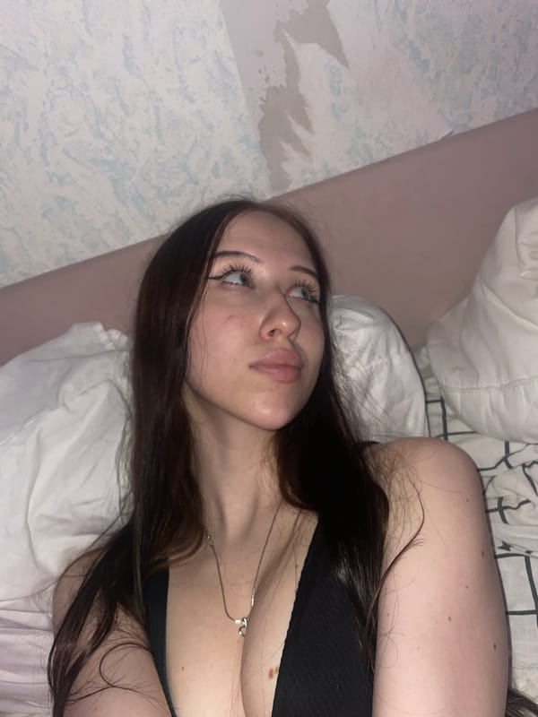 Woman photographed in bedroom with colored lighting in Votkinsk