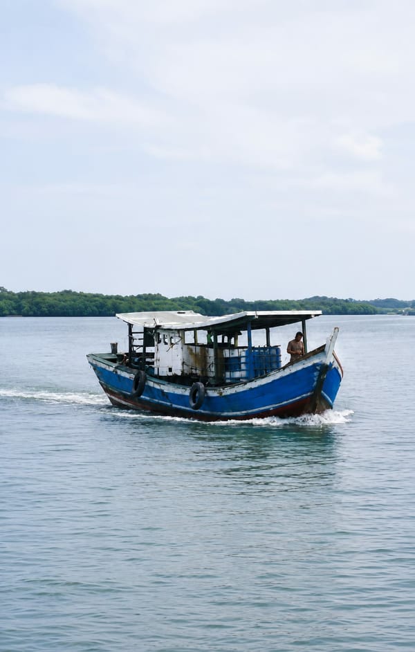 Stilted village and wooden boats along a Medan waterway