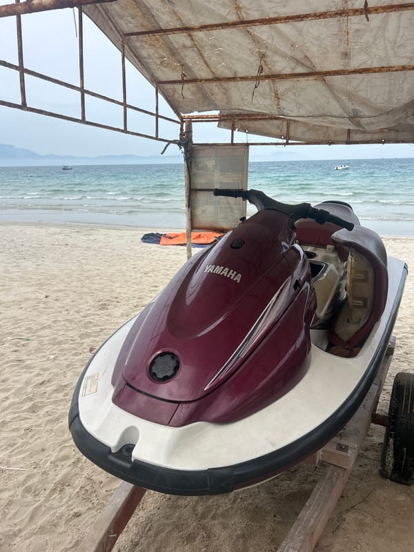 Jet skis parked under canopy on a quiet Vietnamese beach