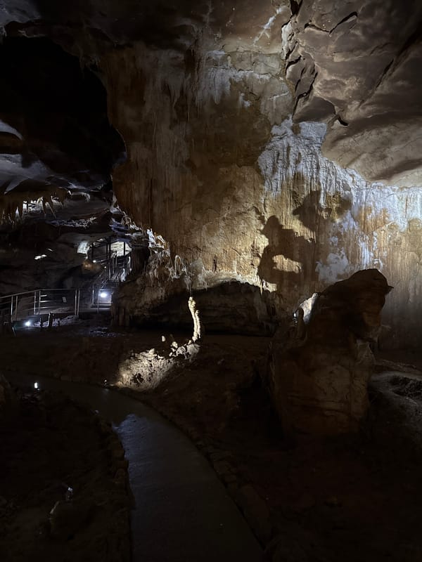 Tourist documents walkthrough of illuminated Prometheus Cave in Georgia