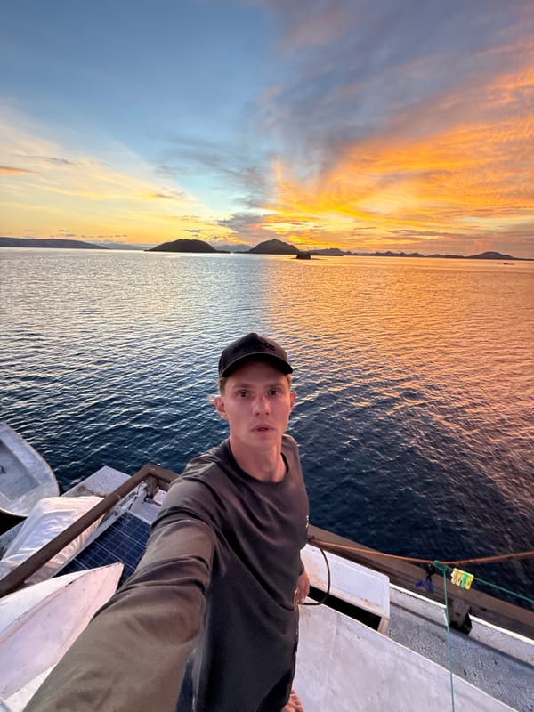 Man photographed on boat deck during Indonesian sunset