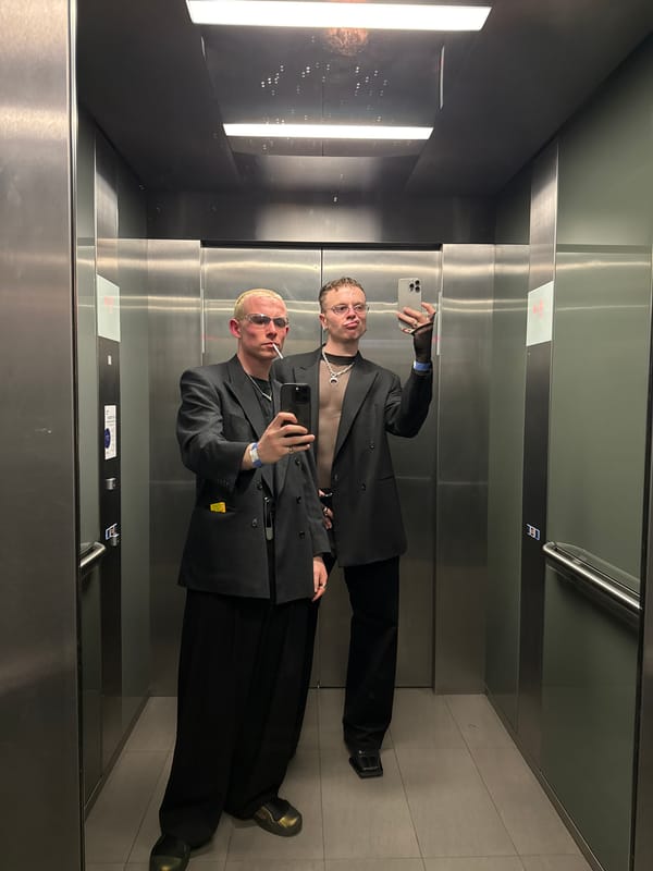 Two people take mirror selfie in London elevator