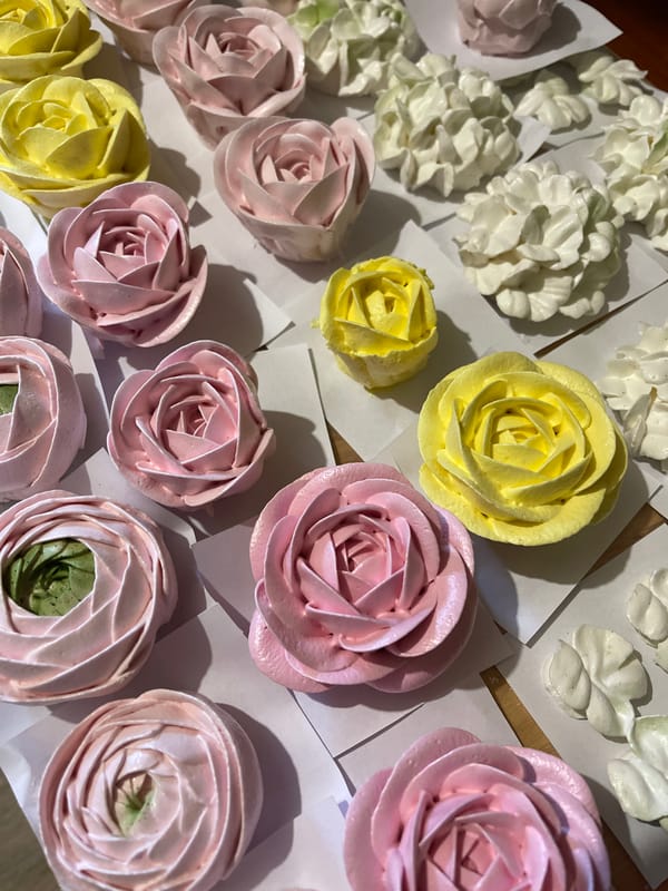 Pastel flower meringues arranged on parchment, shot overhead