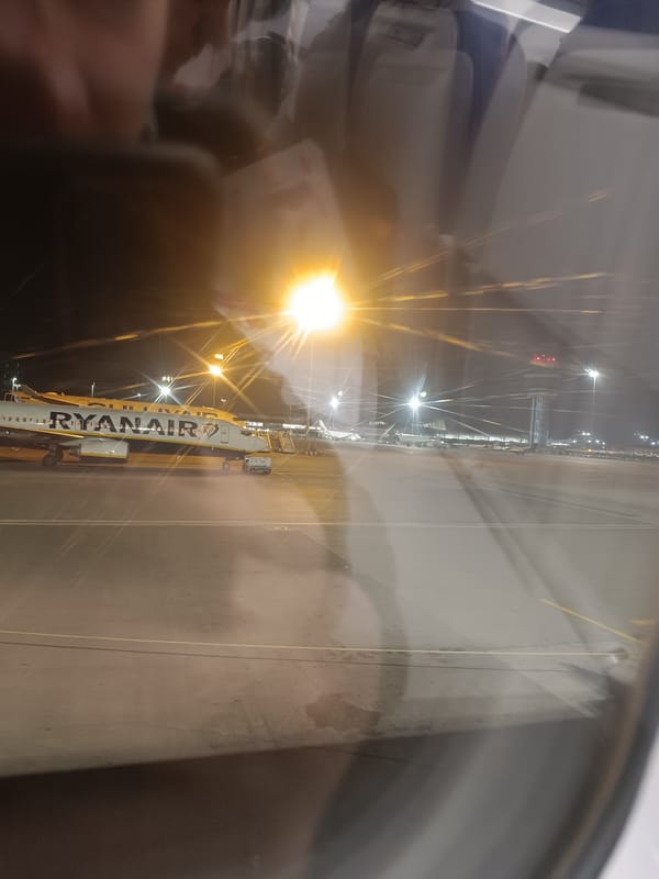 Nighttime airport scene with parked Ryanair aircraft photographed