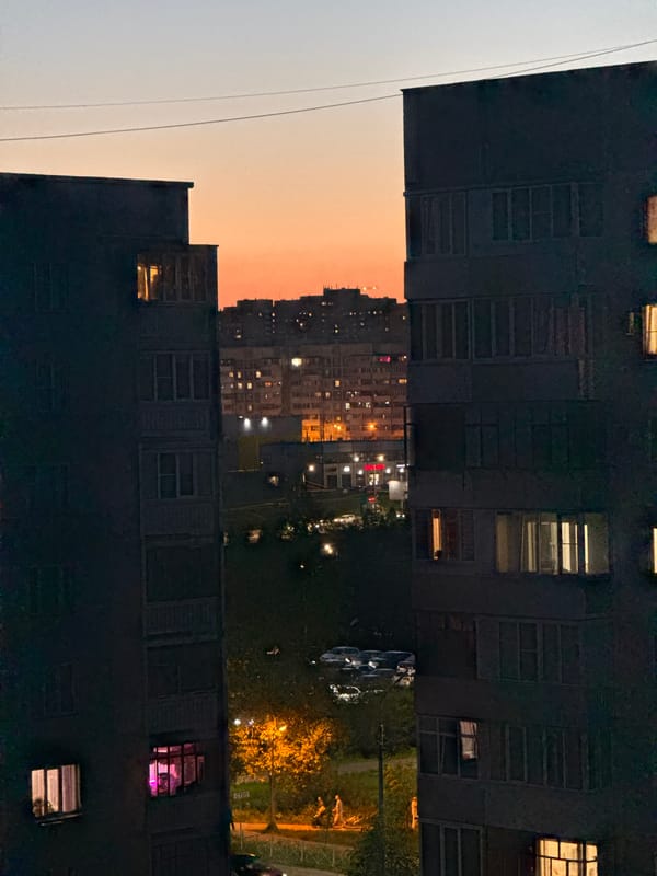 Crescent moon observed over Kazan apartment buildings at twilight
