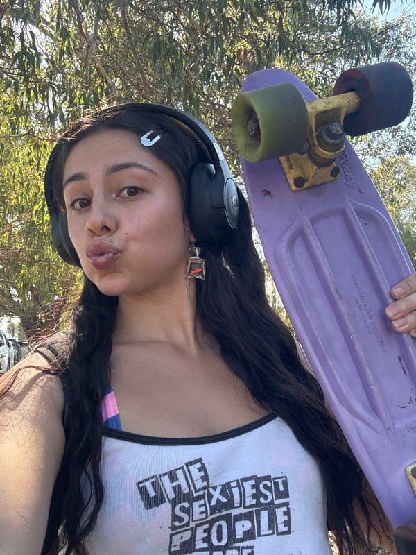 Woman holds purple skateboard overhead in South Perth