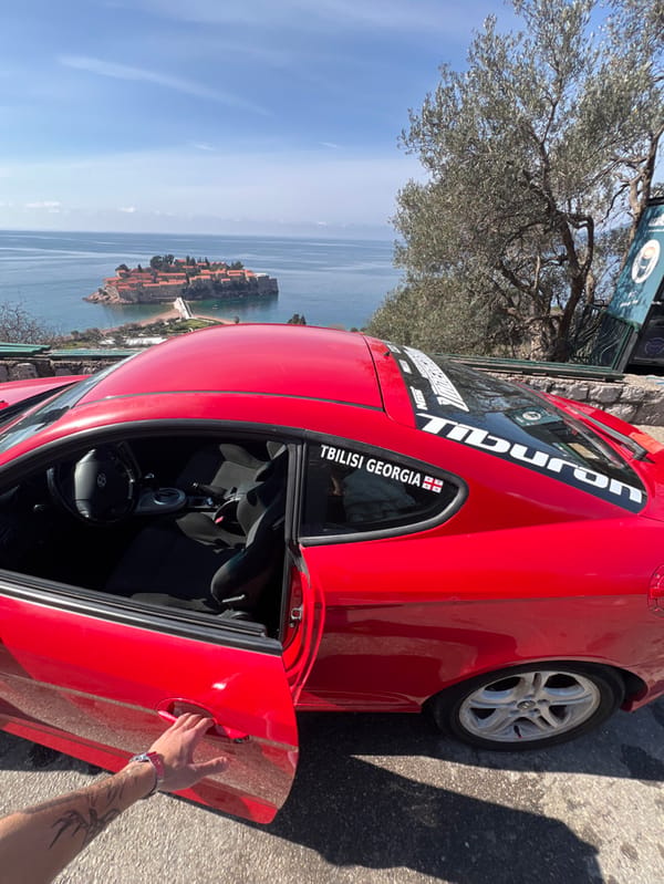 Red sports car documented at Montenegro coastal overlooks