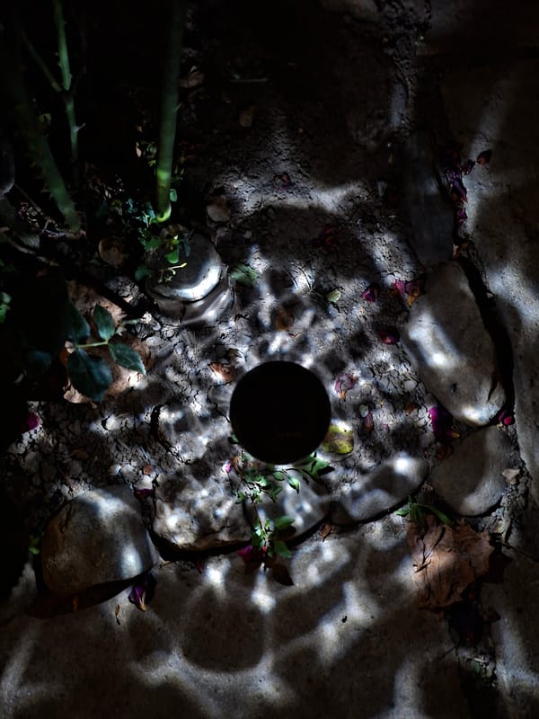 Solar garden light illuminates dark ground near a soil hole
