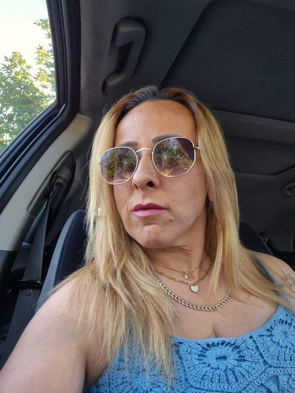 Car interior moment with blonde hair and sunglasses