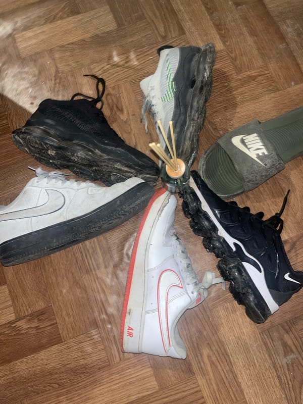 Used shoes arranged in circle on parquet floor