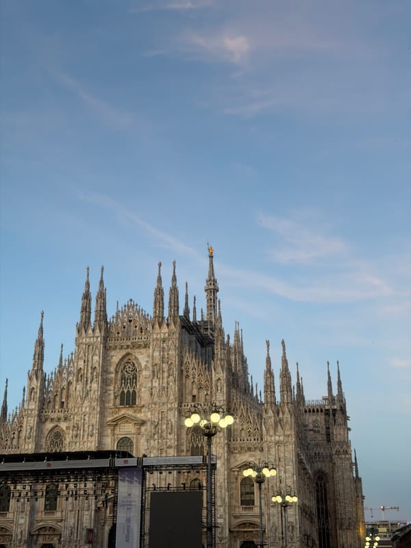 Pedestrians gather around Milan's Duomo during overcast afternoon